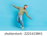 Full size photo of handsome young man bending look back avoid falling dressed stylish khaki outfit isolated on aquamarine color background