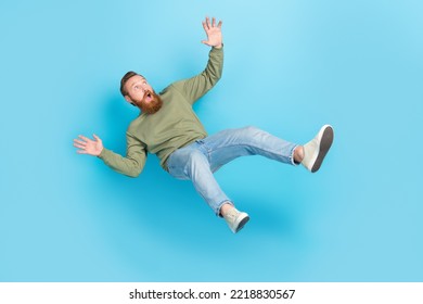 Full size photo of handsome young man frightened falling down slipping dressed stylish khaki outfit isolated on aquamarine color background - Shutterstock ID 2218830567