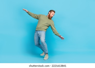 Full size photo of handsome young man bending look back avoid falling dressed stylish khaki outfit isolated on aquamarine color background - Powered by Shutterstock