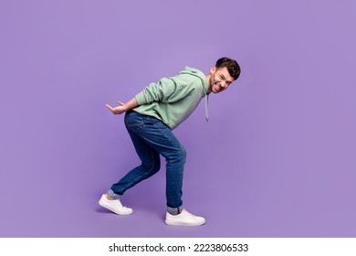 Full size photo of handsome young man carry back heavy object stressed wear trendy gray isolated on violet color background