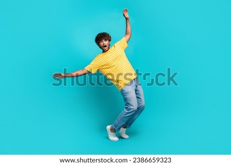 Full size photo of handsome young guy frightened avoid falling dressed stylish striped yellow outfit isolated on cyan color background