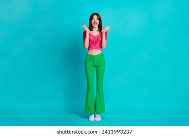 Full size photo of impressed overjoyed girl wear pink top raising palms up staring at awesome offer isolated on blue color background