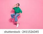 Full size photo of intelligent senior person wear shirt denim trousers sit on chair touching glasses isolated on pink color background
