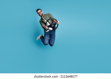 Full size photo of jumping man hold steering wheel traveling having fun isolated on blue color background