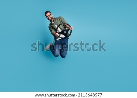 Full size photo of jumping man hold steering wheel traveling having fun isolated on blue color background