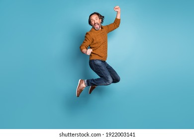 Full size photo of mature handsome excited crazy smiling man jumping in success victory isolated on blue color background