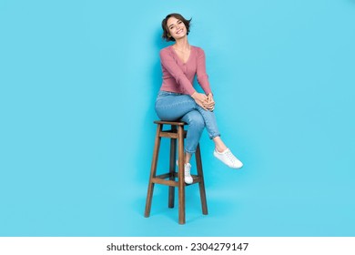 Full size photo of nice cute good mood woman wear pink cardigan sitting on chair hold hands on knee isolated on teal color background - Shutterstock ID 2304279147