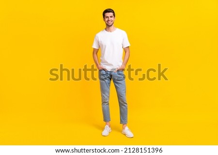 Full size photo of nice millennial brunet guy stand wear eyewear t-shirt jeans shoes isolated on yellow background