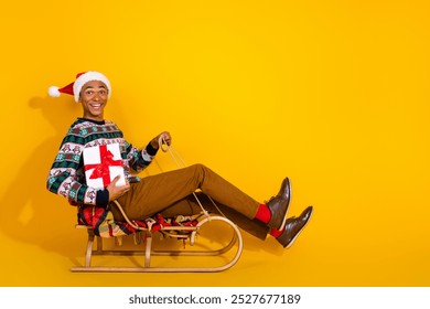 Full size photo of nice young male deliver gift ride sledge wear ornament christmas outfit theme party on yellow color background - Powered by Shutterstock