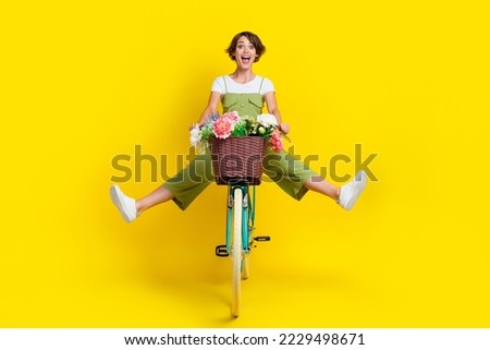 Full size photo of nice young girl driving cycle fast hurry scream energetic wear trendy khaki clothes isolated on yellow color background