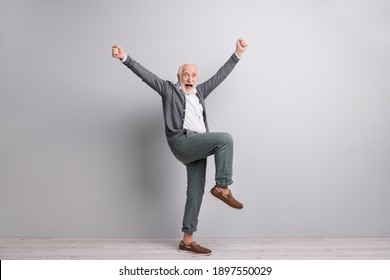 Full Size Photo Of Old Funny Impressed Man Dance Hands Fists Wear Dark Sweater Trousers Boots Isolated On Grey Wall