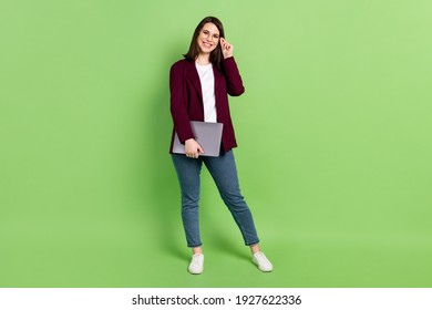 Full Size Photo Of Optimistic Brown Hairdo Lady Stand With Laptop Wear Spectacles Red Cardigan Jeans Sneakers Isolated On Green Background