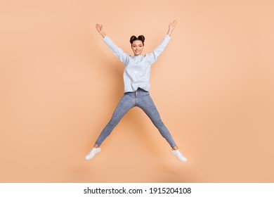 Full size photo of optimistic nice brunette lady jump wear light blue sweater jeans sneakers isolated on beige color background - Shutterstock ID 1915204108
