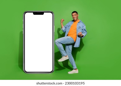 Full size photo of overjoyed energetic male raise fists in victory win new smartphone isolated on green color background - Powered by Shutterstock