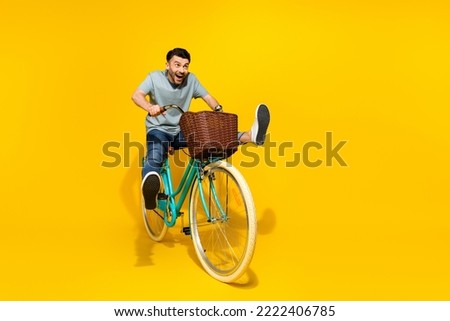 Full size photo of overjoyed positive person ride bicycle empty space isolated on yellow color background