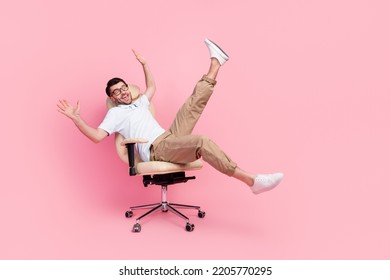Full size photo of playful guy manager fooling ride fast cozy office chair isolated on pastel color background