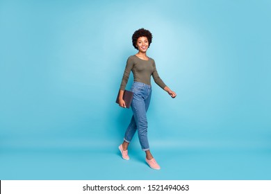 Full Size Photo Of Positive Confident Independent Cool Dark Skin Girl Freelancer Go Walk For Job In Company Hold Her Netbook Wear Casual Style Clothes Pink Sneakers Isolated Blue Color Background