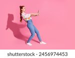 Full size photo of positive girl dressed colorful blouse jeans hold palms say stop look empty space isolated on pink color background