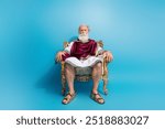 Full size photo of powerful mature man sit golden throne wear ancient roman emperor tunic isolated on blue color background