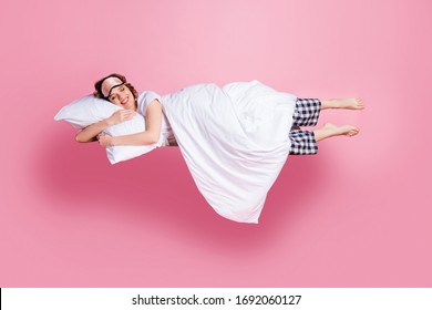 Full size photo of pretty cheerful lady satisfied morning nap lying bed hug pillow covered blanket wear mask white t-shirt plaid pajama pants barefoot isolated pink color background - Powered by Shutterstock