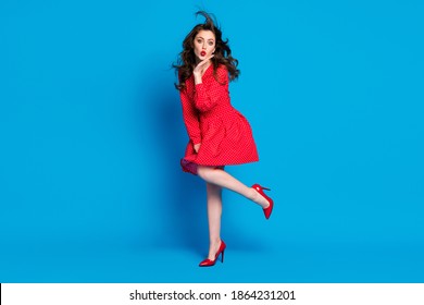 Full size photo of pretty person arm under chin kiss wind raise vintage clothing isolated on blue color background - Powered by Shutterstock