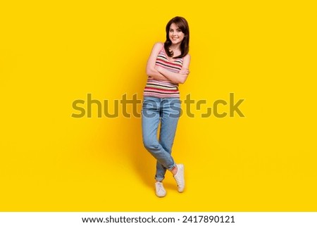 Full size photo of satisfied lovely woman dressed knitwear top jeans pants standing arms crossed isolated on yellow color background