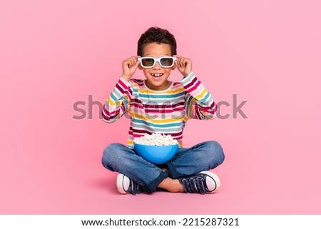 Full size photo of sitting impressed boy wear striped shirt jeans 3d glasses watch amazing movie isolated on pink color background