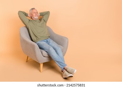 Full Size Photo Of Sleepy Old Grey Hairdo Man Sit Wear Pullover Jeans Shoes Isolated On Beige Background