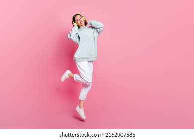 Full size photo of sweet bob hairstyle millennial lady jump wear headphones hoodie pants shoes isolated on pink background