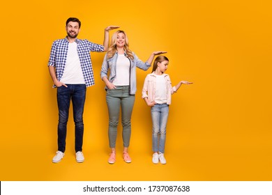 Full Size Photo Of Three Members Family Mom Dad Daughter Not Believe Quick Growing Up Measuring Length Height Good Mood Wear Casual Outfit Isolated Yellow Color Background