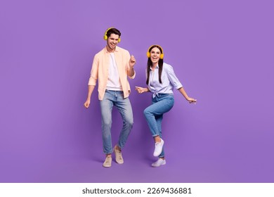 Full size photo of two overjoyed positive people enjoy listen music dancing chilling isolated on violet color background - Powered by Shutterstock