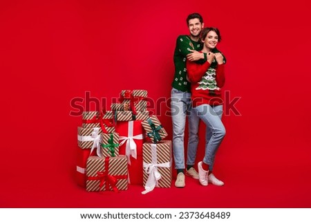 Full size photo of two peaceful idyllic partners cuddle pile stack newyear giftbox prepare party isolated on red color background