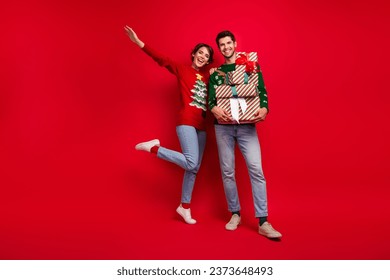 Full size photo of two positive funky people rejoice hold pile stack christmastime giftbox isolated on red color background