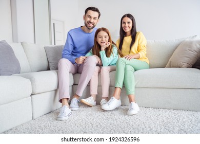 Full size photo of young cheerful family mommy daddy daughter happy positive toothy smile sit couch home