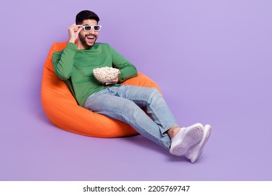 Full Size Photo Of Young Excited Hispanic Man Watching Movie Eat Popcorn Dressed Trendy Green Outfit Isolated On Violet Color Background