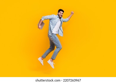 Full Size Photo Of Young Guy Holding Laptop Jump Run Air Future Technologies Isolated On Yellow Color Background