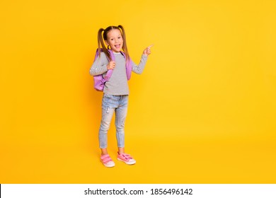 Full Size Photo Of Young Happy Smiling School Girl Wear Backpack Pointing Finger In Copyspace Isolated On Yellow Color Background