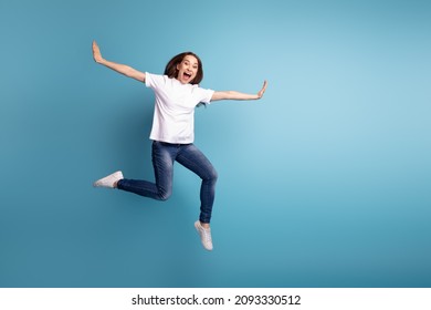 Full size photo of young pretty girl enjoy fly arms wings dreamy wear casual clothes isolated over blue color background - Shutterstock ID 2093330512