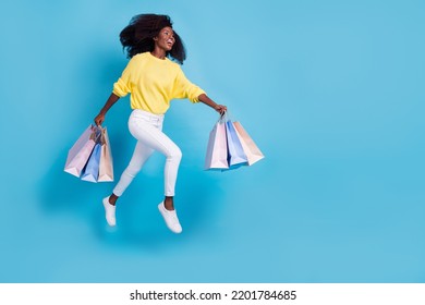 Full Size Photo Of Young Smiling Lady Holding Bags Recycle Old Clothes Look Empty Space Isolated On Blue Color Background