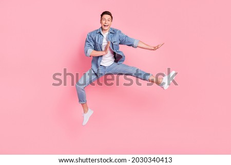 Full size photo of young smiling good mood positive man jumping dancing in air isolated on pink color background