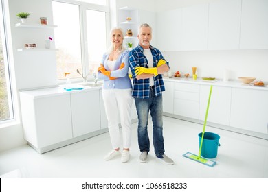 Full size portrait of attractive cleanly neat cheerful stylish couple of senior in colorful protective gloves standing with crossed arms after cleaning, looking at camera, having mop, bucket - Powered by Shutterstock