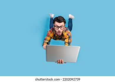 Full size portrait of craze geek man falling hands hold use netbook isolated on blue color background - Shutterstock ID 2202092739