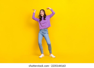 Full size portrait of impressed hardworking girl arms hold heavy empty space isolated on yellow color background