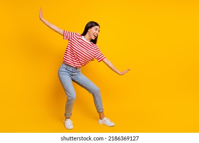 Full size portrait of overjoyed cheerful person arms make funny pose look empty space isolated on yellow color background - Shutterstock ID 2186369127