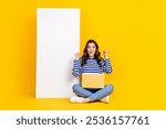 Full size portrait of overjoyed delighted girl sit floor use wireless netbook huge empty space display isolated on yellow color background