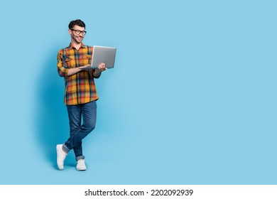 Full size portrait of positive nice person hold use wireless netbook empty space isolated on blue color background - Powered by Shutterstock