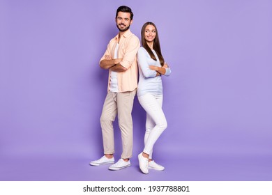 Full Size Portrait Of Two Cheerful Persons Standing Back To Back Folded Arms Isolated On Purple Color Background