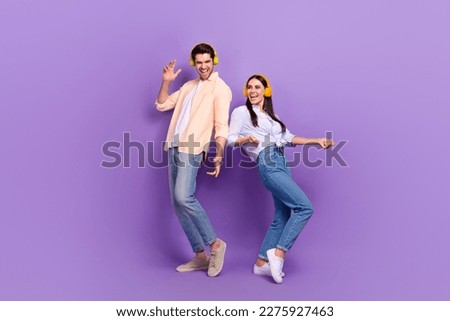 Full size portrait of two cheerful carefree people dancing have good mood isolated on purple color background