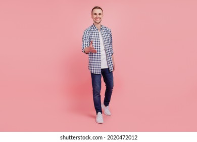 Full size portrait of young handsome guy go walk hold hand meeting handshake happy positive smile isolated over pink background - Powered by Shutterstock