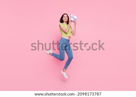 Full size of positive smiling lady jumping hold small birthday present giftbox isolated on pink color background
